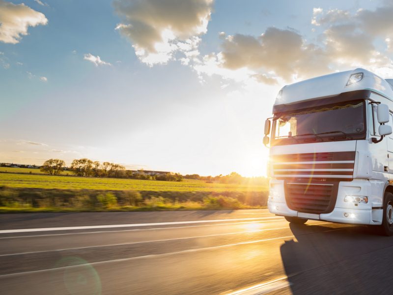 Truck with container on highway, cargo transportation concept. Shaving effect.